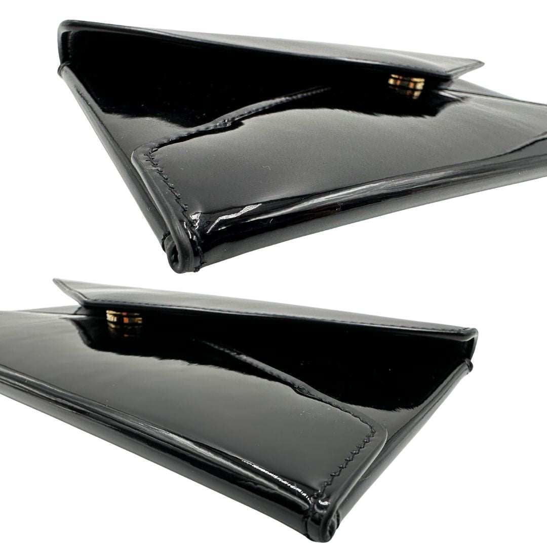 Angoli di una pochette Paloma Envelope Saint Laurent in vernice nera lucida con chiusura a bottone a pressione e parti metalliche dorate. Interno in pelle con logo impresso. Completa di scatola e sacchetto antipolvere.