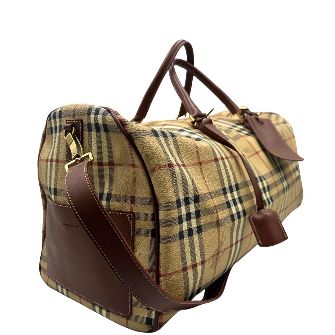 lato Borsone Burberry in canvas trama tartan con finiture in pelle marroni e parti metalliche dorate; munito di doppi manici stondati e una tracolla amovibile. Completo di lucchetto e chiavi, di lusso, originale, ottime condizioni. 