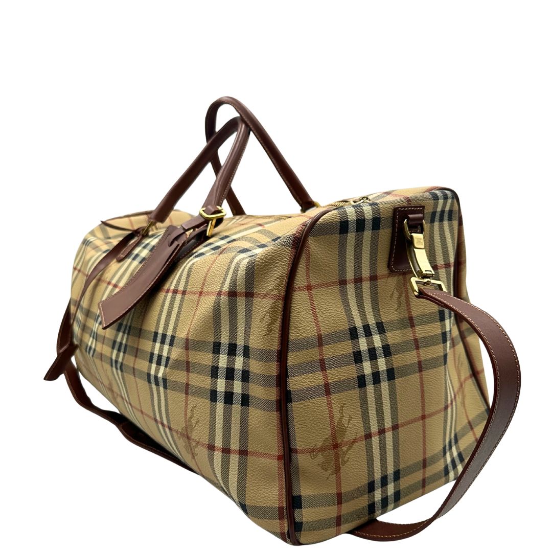 lato Borsone Burberry in canvas trama tartan con finiture in pelle marroni e parti metalliche dorate; munito di doppi manici stondati e una tracolla amovibile. Completo di lucchetto e chiavi, di lusso, originale, ottime condizioni. 