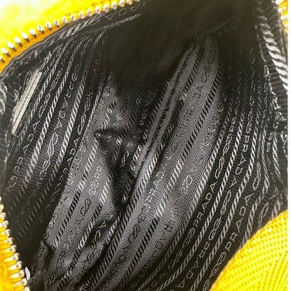 interno Borsa Prada in spugna gialla con logo nero sul front e parti metalliche argentate; munita di un manico singolo in tessuto, indossabile a spalla o a mano. Completa di dustbag, di lusso, originale, ottime condizioni. 