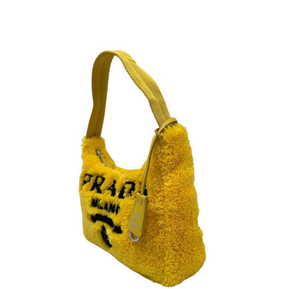 lato Borsa Prada in spugna gialla con logo nero sul front e parti metalliche argentate; munita di un manico singolo in tessuto, indossabile a spalla o a mano. Completa di dustbag, di lusso, originale, ottime condizioni. 