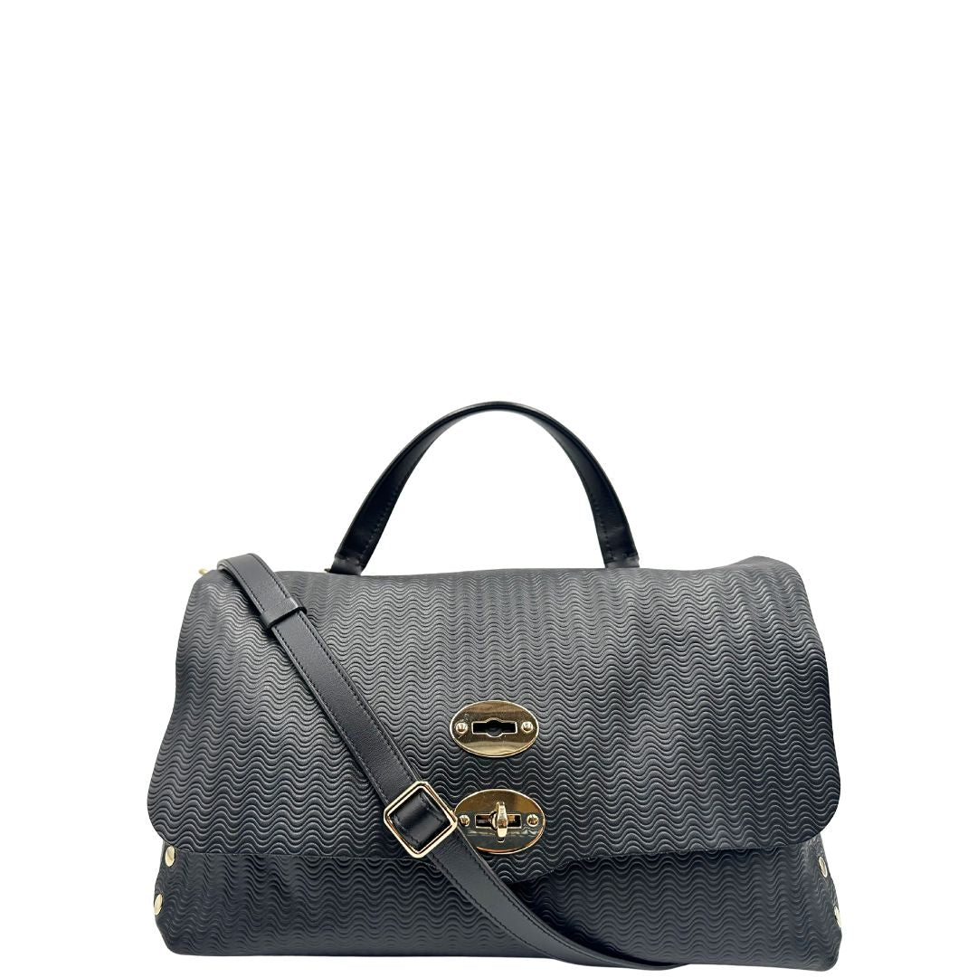 Front di una borsa Zanellato in pelle nera trama Blandine con parti metalliche oro chiaro; munita di un manico singolo e una tracolla amovibile e regolabile. Completa di dustbag.