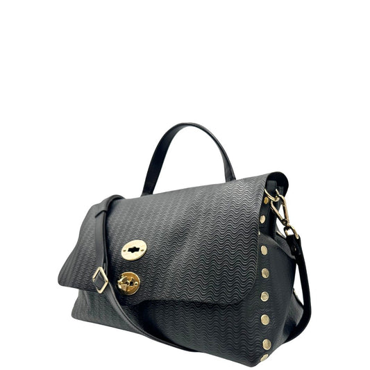 Laterale destro di una borsa Zanellato in pelle nera trama Blandine con parti metalliche oro chiaro; munita di un manico singolo e una tracolla amovibile e regolabile. Completa di dustbag.