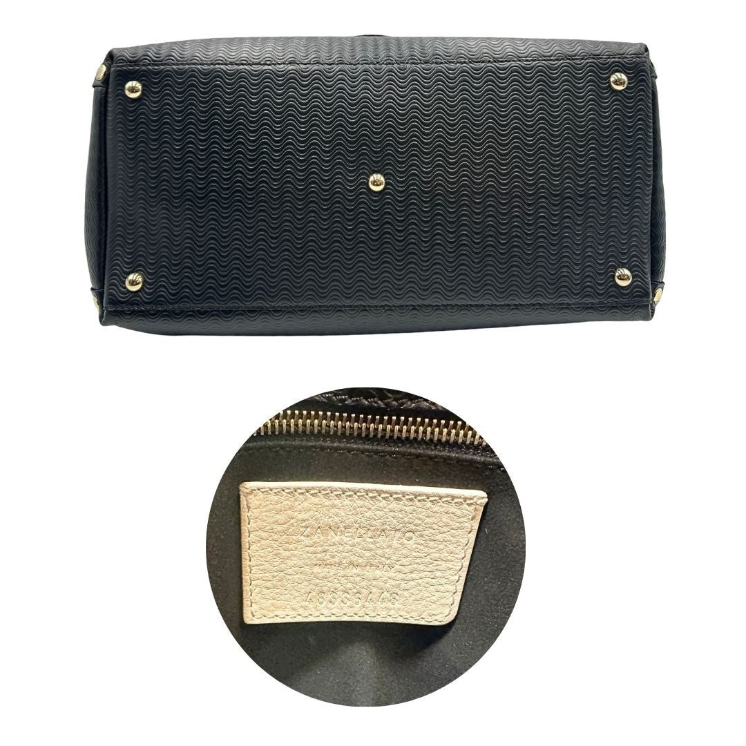 Base e codice di una borsa Zanellato in pelle nera trama Blandine con parti metalliche oro chiaro; munita di un manico singolo e una tracolla amovibile e regolabile. Completa di dustbag.