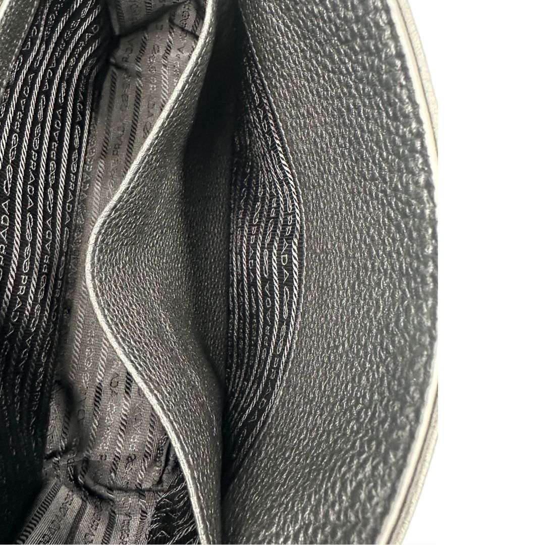interno Borsa Prada in pelle martellata nera con parti metalliche argentate; munita di una tracolla regolabile. Completa di dustbag, di lusso, originale, eccellenti condizioni, usata. 