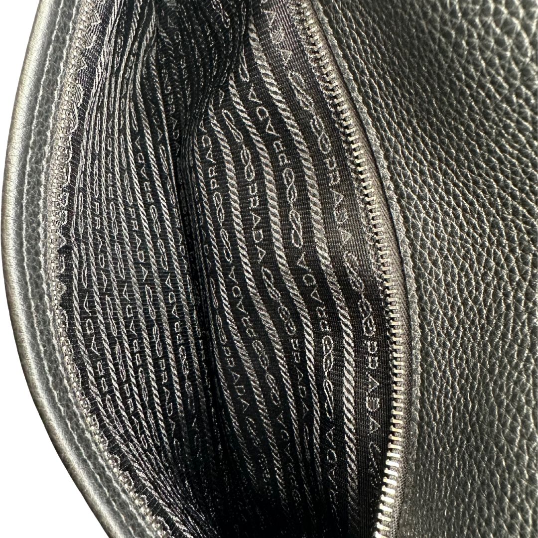 interno Borsa Prada in pelle martellata nera con parti metalliche argentate; munita di una tracolla regolabile. Completa di dustbag, di lusso, originale, eccellenti condizioni, usata. 