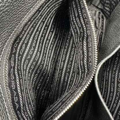 interno Borsa Prada in pelle martellata nera con parti metalliche argentate; munita di una tracolla regolabile. Completa di dustbag, di lusso, originale, eccellenti condizioni, usata. 