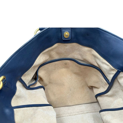 Interno di una Borsa Prada in pelle blu notte con parti metalliche dorate; munita di un accessorio porta address, doppi manici stondati e una tracolla amovibile e regolabile. Indossabile a mano oppure a tracolla. Originale, usata, di lusso, in ottime condizioni.