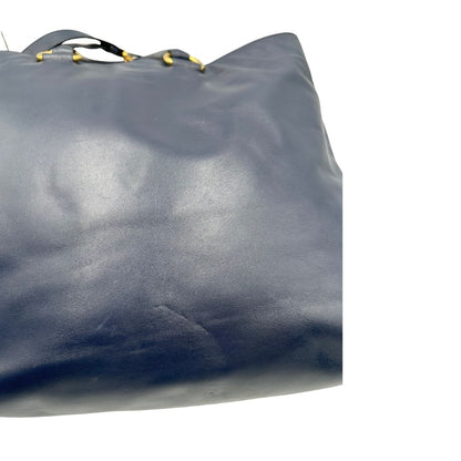 Retro di una Borsa Prada in pelle blu notte con parti metalliche dorate; munita di un accessorio porta address, doppi manici stondati e una tracolla amovibile e regolabile. Indossabile a mano oppure a tracolla. Originale, usata, di lusso, in ottime condizioni.