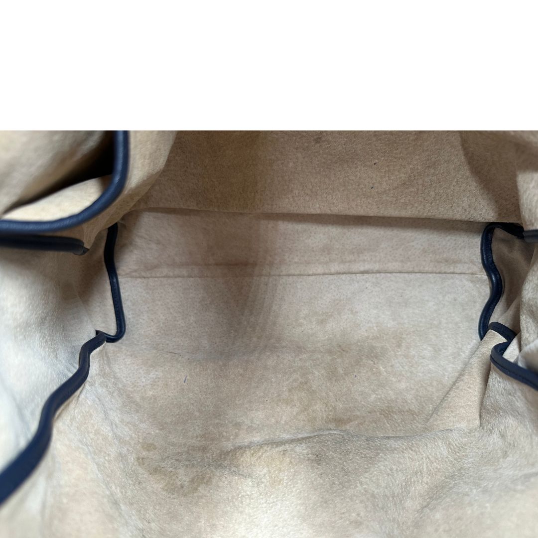 Interno di una Borsa Prada in pelle blu notte con parti metalliche dorate; munita di un accessorio porta address, doppi manici stondati e una tracolla amovibile e regolabile. Indossabile a mano oppure a tracolla. Originale, usata, di lusso, in ottime condizioni.