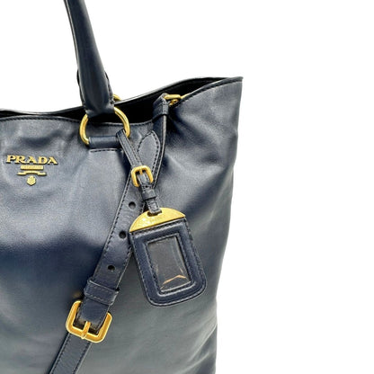 Borsa Prada in pelle blu notte con parti metalliche dorate; munita di un accessorio porta address, doppi manici stondati e una tracolla amovibile e regolabile. Indossabile a mano oppure a tracolla. Originale, usata, di lusso, in ottime condizioni.