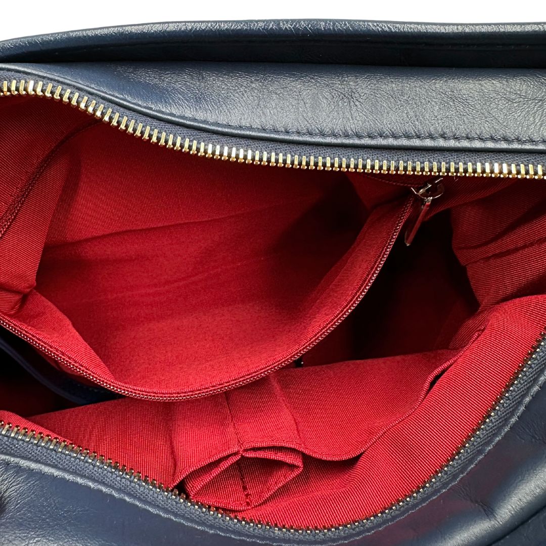 Interno di una borsa Chanel Gabrielle in pelle matelassé blu navy con parti metalliche dorate e argentate. Munita di una tracolla in catena e pelle intrecciata con spallaccio. Tirante delle cerniera impreziosito dall'iconico logo CC in metallo dorato, completa di corredo.