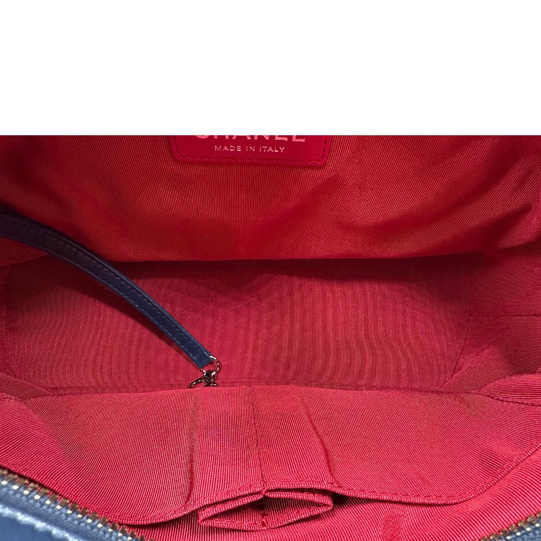 Interno di una borsa Chanel Gabrielle in pelle matelassé blu navy con parti metalliche dorate e argentate. Munita di una tracolla in catena e pelle intrecciata con spallaccio. Tirante delle cerniera impreziosito dall'iconico logo CC in metallo dorato, completa di corredo.