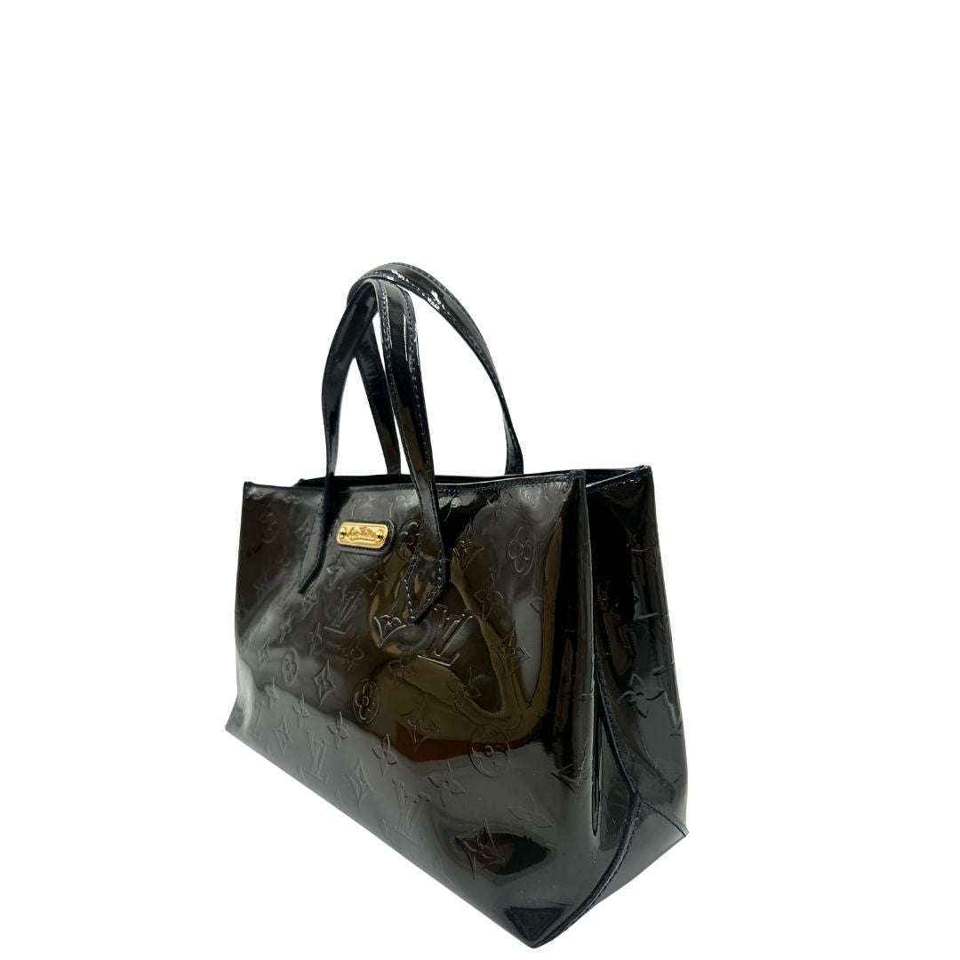 lato Borsa Louis Vuitton in pelle verniciata marrone con riflessi che tendono al verde e parti metalliche dorate; munita di doppi manici, da portare a mano. Completa di corredo, di lusso, originale, ottime condizioni, usata. 