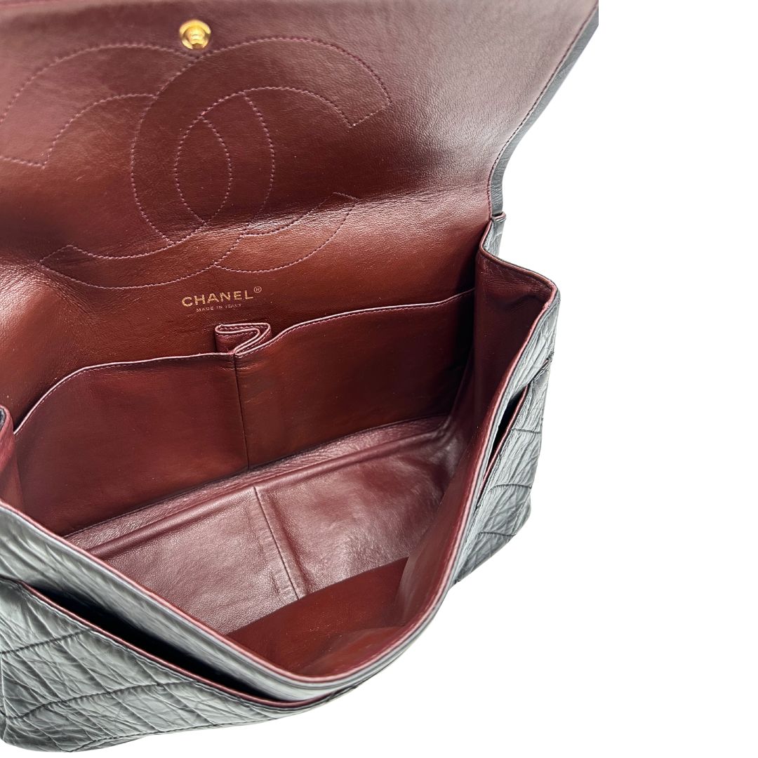 Interno di una borsa Chanel 2.55 in pelle aged nera trapuntata, con parti metalliche dorate. Munita di una tracolla scorrevole in catena. Indossabile a spalla o a tracolla. Completa di scatola.