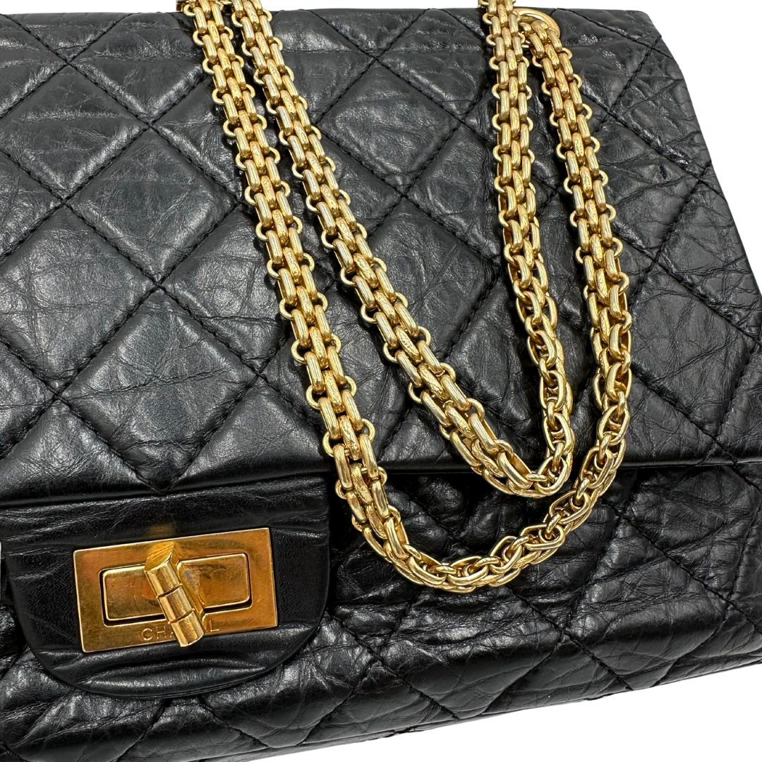 Parti metalliche di una borsa Chanel 2.55 in pelle aged nera trapuntata, con parti metalliche dorate. Munita di una tracolla scorrevole in catena. Indossabile a spalla o a tracolla. Completa di scatola.