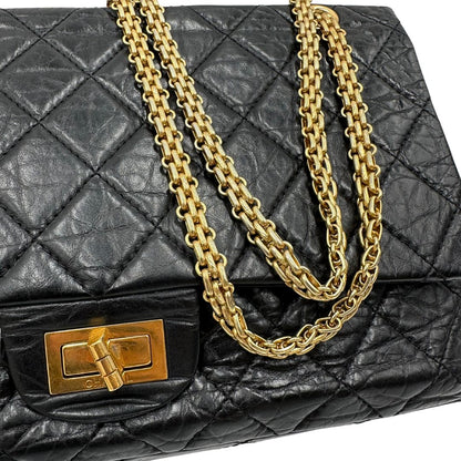Parti metalliche di una borsa Chanel 2.55 in pelle aged nera trapuntata, con parti metalliche dorate. Munita di una tracolla scorrevole in catena. Indossabile a spalla o a tracolla. Completa di scatola.
