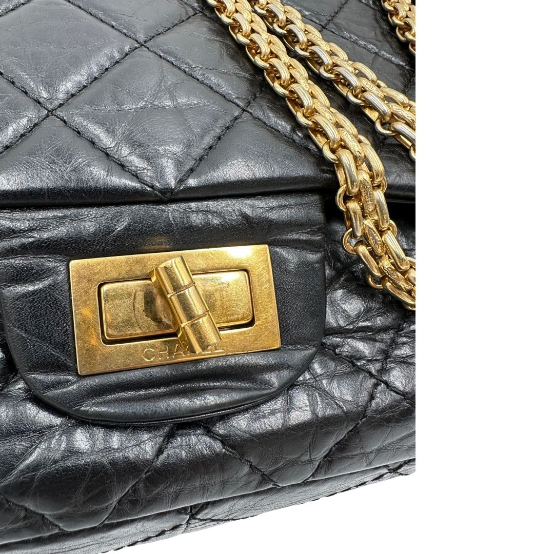 Parti metalliche di una borsa Chanel 2.55 in pelle aged nera trapuntata, con parti metalliche dorate. Munita di una tracolla scorrevole in catena. Indossabile a spalla o a tracolla. Completa di scatola.