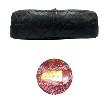 Base e codice di una borsa Chanel 2.55 in pelle aged nera trapuntata, con parti metalliche dorate. Munita di una tracolla scorrevole in catena. Indossabile a spalla o a tracolla. Completa di scatola.