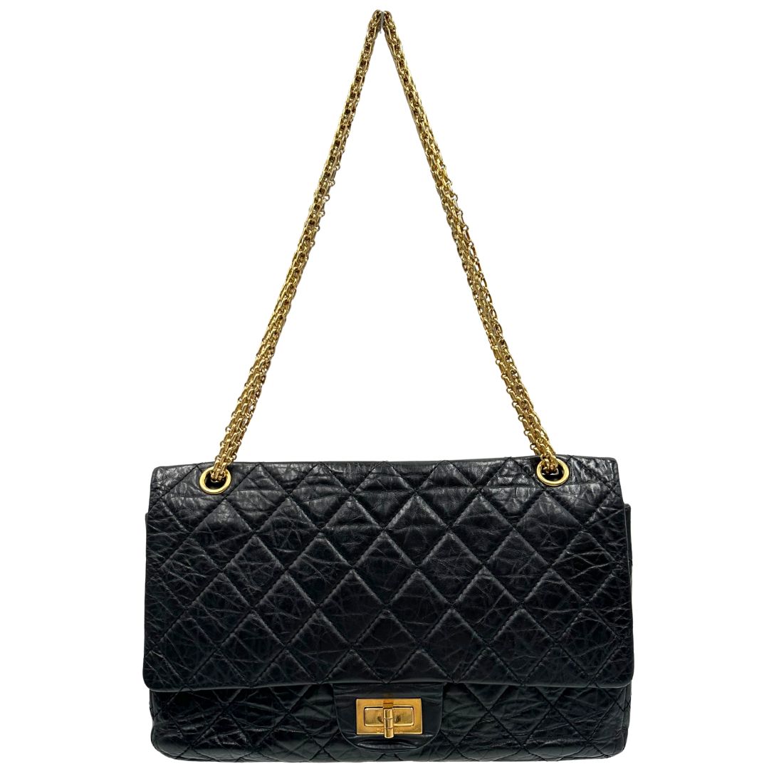Front di una borsa Chanel 2.55 in pelle aged nera trapuntata, con parti metalliche dorate. Munita di una tracolla scorrevole in catena. Indossabile a spalla o a tracolla. Completa di scatola.