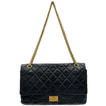 Front di una borsa Chanel 2.55 in pelle aged nera trapuntata, con parti metalliche dorate. Munita di una tracolla scorrevole in catena. Indossabile a spalla o a tracolla. Completa di scatola.