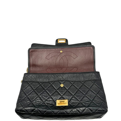 Apertura di una borsa Chanel 2.55 in pelle aged nera trapuntata, con parti metalliche dorate. Munita di una tracolla scorrevole in catena. Indossabile a spalla o a tracolla. Completa di scatola.