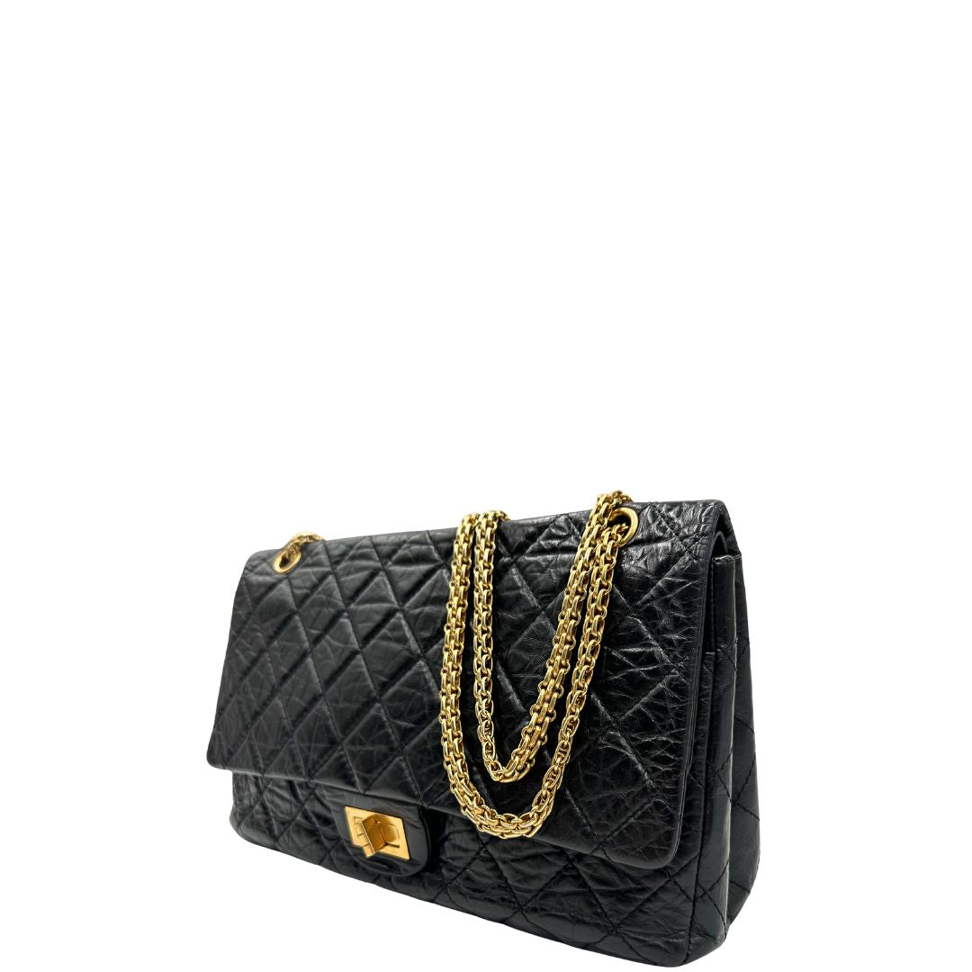 Laterale destro di una borsa Chanel 2.55 in pelle aged nera trapuntata, con parti metalliche dorate. Munita di una tracolla scorrevole in catena. Indossabile a spalla o a tracolla. Completa di scatola.