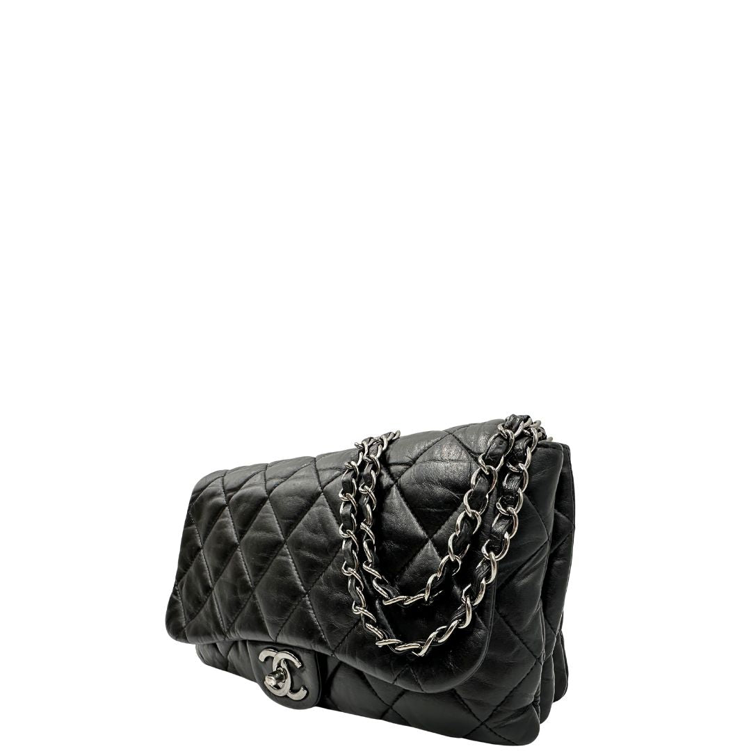Lato sinistro di una Borsa Chanel in pelle nera matelassè e parti metalliche argentate; munita di una tracolla scorrevole in catena e pelle. Indossabile a spalla e a tracolla. Completa di scatola. Originale, usata, di lusso, in condizioni eccellenti.