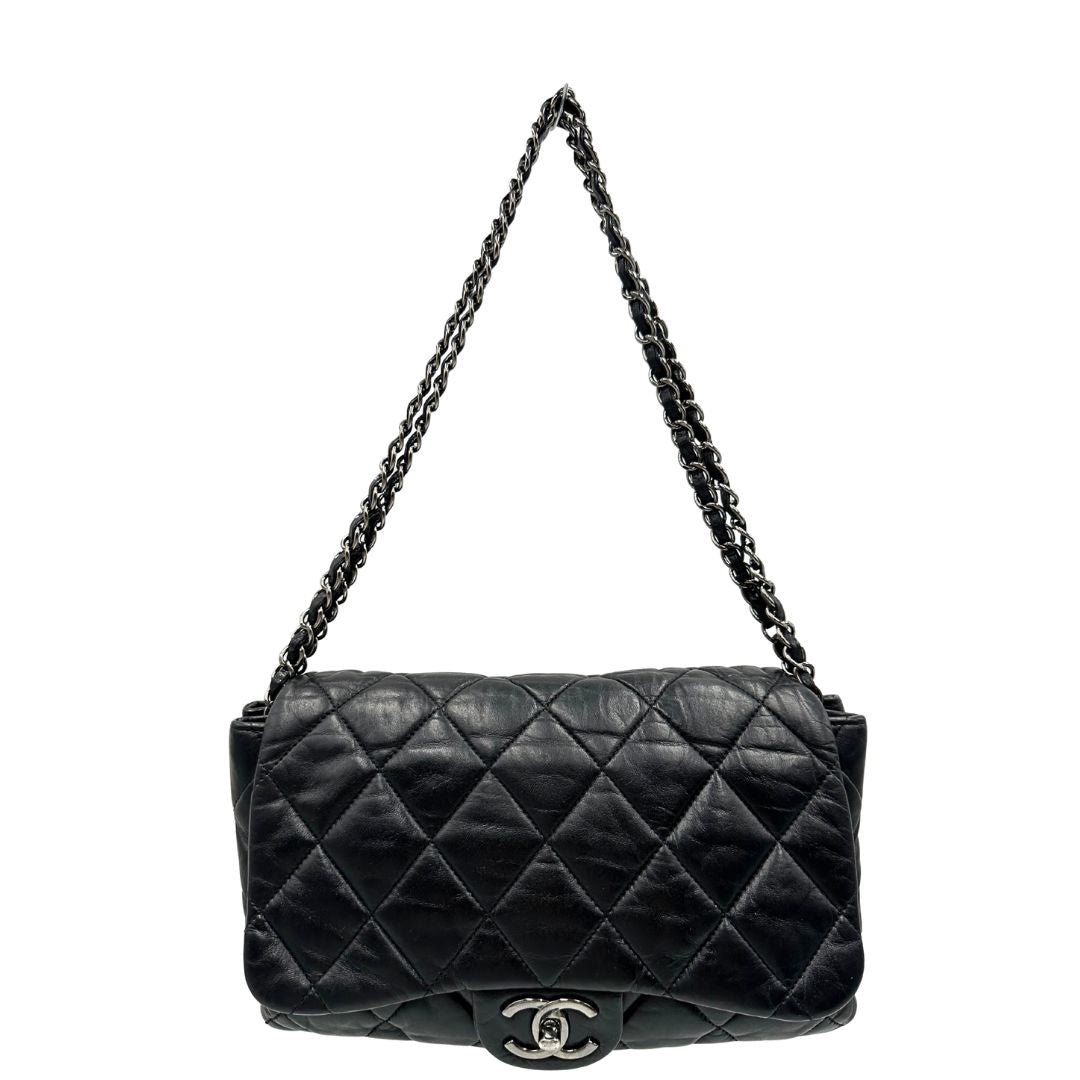 Front di una Borsa Chanel in pelle nera matelassè e parti metalliche argentate; munita di una tracolla scorrevole in catena e pelle. Indossabile a spalla e a tracolla. Completa di scatola. Originale, usata, di lusso, in condizioni eccellenti.