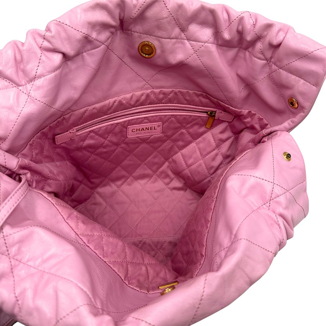 Interno di una borsa Chanel 22 in pelle trapuntata rosa con parti metalliche dorate; dotata di pochette estraibile e amovibile, doppi manici in catena e pelle per portarla a spalla. Chiusura con bottone automatici. Completa di scatola e dustbag.