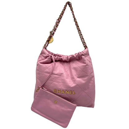 Front di una borsa Chanel 22 in pelle trapuntata rosa con parti metalliche dorate; dotata di pochette estraibile e amovibile, doppi manici in catena e pelle per portarla a spalla. Chiusura con bottone automatici. Completa di scatola e dustbag.