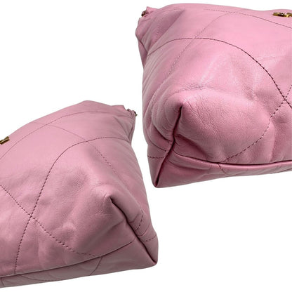 Angoli di una borsa Chanel 22 in pelle trapuntata rosa con parti metalliche dorate; dotata di pochette estraibile e amovibile, doppi manici in catena e pelle per portarla a spalla. Chiusura con bottone automatici. Completa di scatola e dustbag.