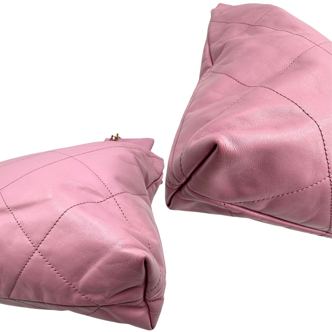 Angoli di una borsa Chanel 22 in pelle trapuntata rosa con parti metalliche dorate; dotata di pochette estraibile e amovibile, doppi manici in catena e pelle per portarla a spalla. Chiusura con bottone automatici. Completa di scatola e dustbag.