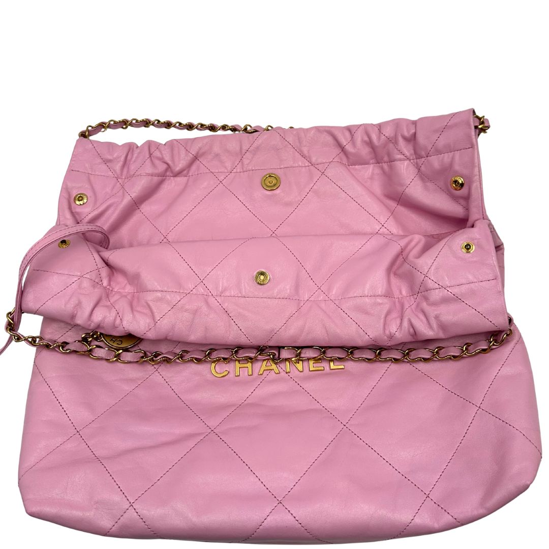 Apertura di una borsa Chanel 22 in pelle trapuntata rosa con parti metalliche dorate; dotata di pochette estraibile e amovibile, doppi manici in catena e pelle per portarla a spalla. Chiusura con bottone automatici. Completa di scatola e dustbag.
