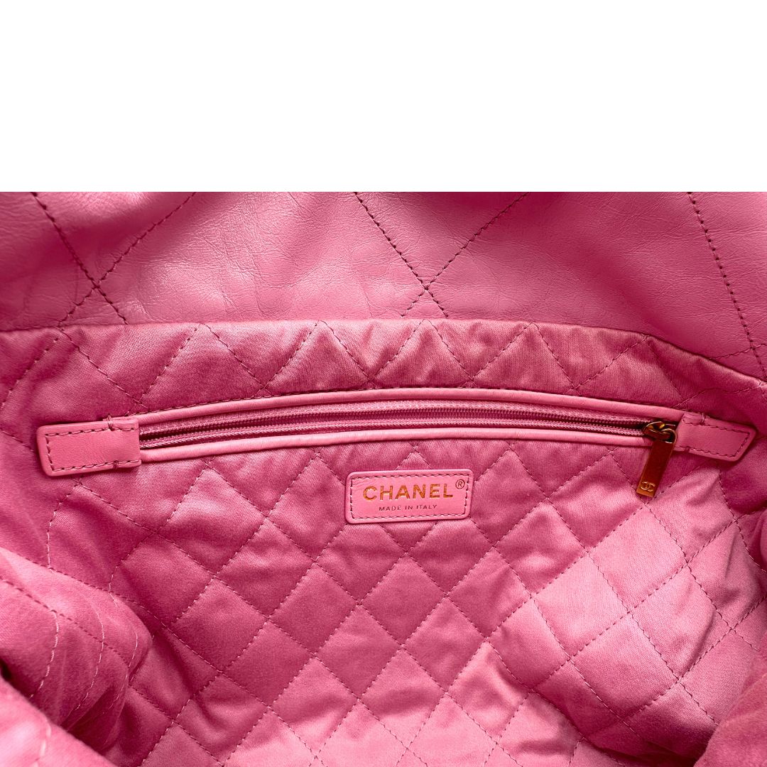 Interno di una borsa Chanel 22 in pelle trapuntata rosa con parti metalliche dorate; dotata di pochette estraibile e amovibile, doppi manici in catena e pelle per portarla a spalla. Chiusura con bottone automatici. Completa di scatola e dustbag.
