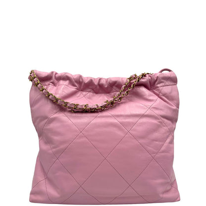 Retro di una borsa Chanel 22 in pelle trapuntata rosa con parti metalliche dorate; dotata di pochette estraibile e amovibile, doppi manici in catena e pelle per portarla a spalla. Chiusura con bottone automatici. Completa di scatola e dustbag.