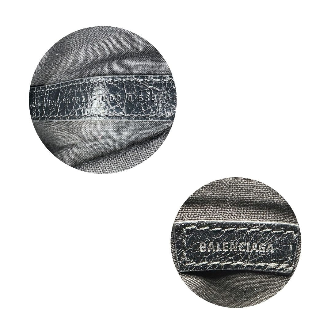 Codice di una pochette Balenciaga in pelle effetto invecchiato nera, con parti metalliche argentate; munita di uno specchietto a forma di cuore, polsino amovibile e un mini porta monete e carte. Completa di dustbag.