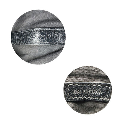 Codice di una pochette Balenciaga in pelle effetto invecchiato nera, con parti metalliche argentate; munita di uno specchietto a forma di cuore, polsino amovibile e un mini porta monete e carte. Completa di dustbag.