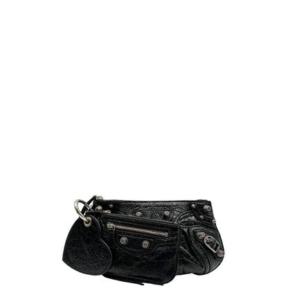 Front di una pochette Balenciaga in pelle effetto invecchiato nera, con parti metalliche argentate; munita di uno specchietto a forma di cuore, polsino amovibile e un mini porta monete e carte. Completa di dustbag.