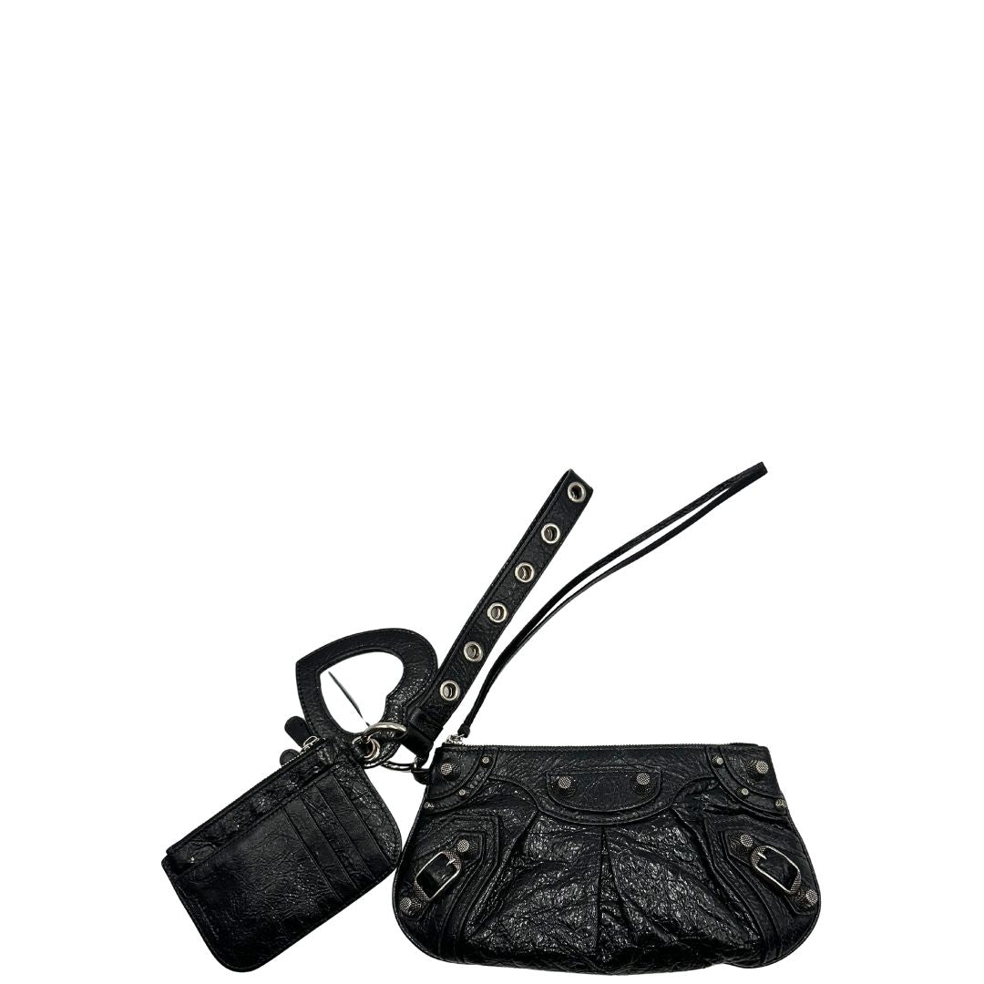 Front di una pochette Balenciaga in pelle effetto invecchiato nera, con parti metalliche argentate; munita di uno specchietto a forma di cuore, polsino amovibile e un mini porta monete e carte. Completa di dustbag.