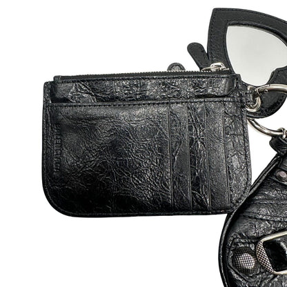Porta monete e carte di una pochette Balenciaga in pelle effetto invecchiato nera, con parti metalliche argentate; munita di uno specchietto a forma di cuore e polsino amovibile. Completa di dustbag.