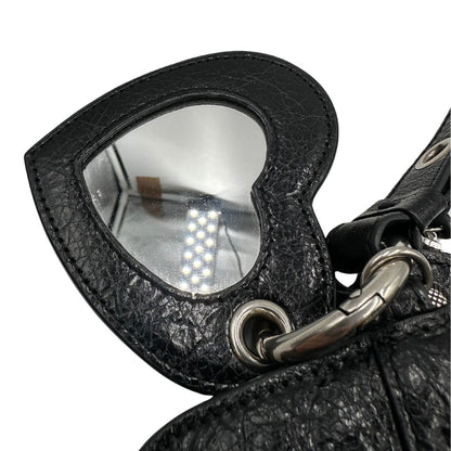 Specchietto a fora di cuore di una pochette Balenciaga in pelle effetto invecchiato nera, con parti metalliche argentate; munita di un polsino amovibile e un mini porta monete e carte. Completa di dustbag.