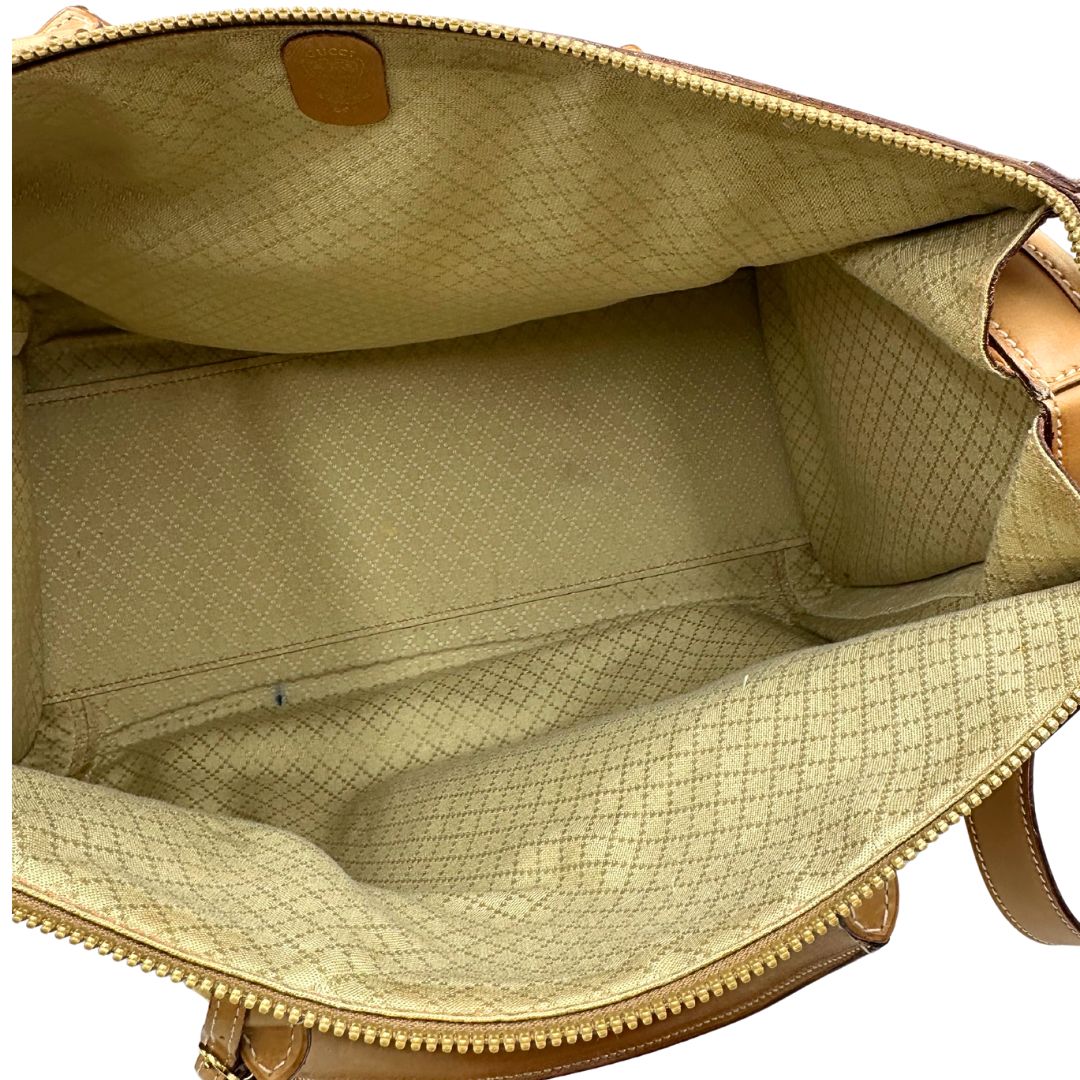 Interno di una borsa Gucci in canvas beige GG con finiture in pelle color cammello e parti metalliche dorate, munita di doppi manici stondati e di una tracolla amovibile e regolabile. Dotata di tag porta address.