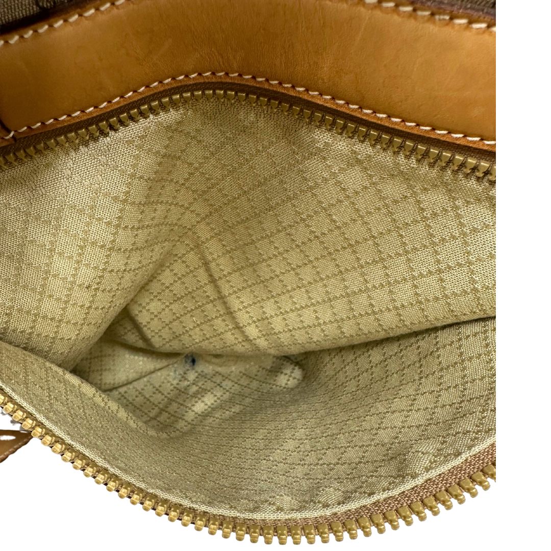 Vista interna del taschino di una borsa Gucci in canvas beige GG con finiture in pelle color cammello e parti metalliche dorate, munita di doppi manici stondati e di una tracolla amovibile e regolabile. Dotata di tag porta address.