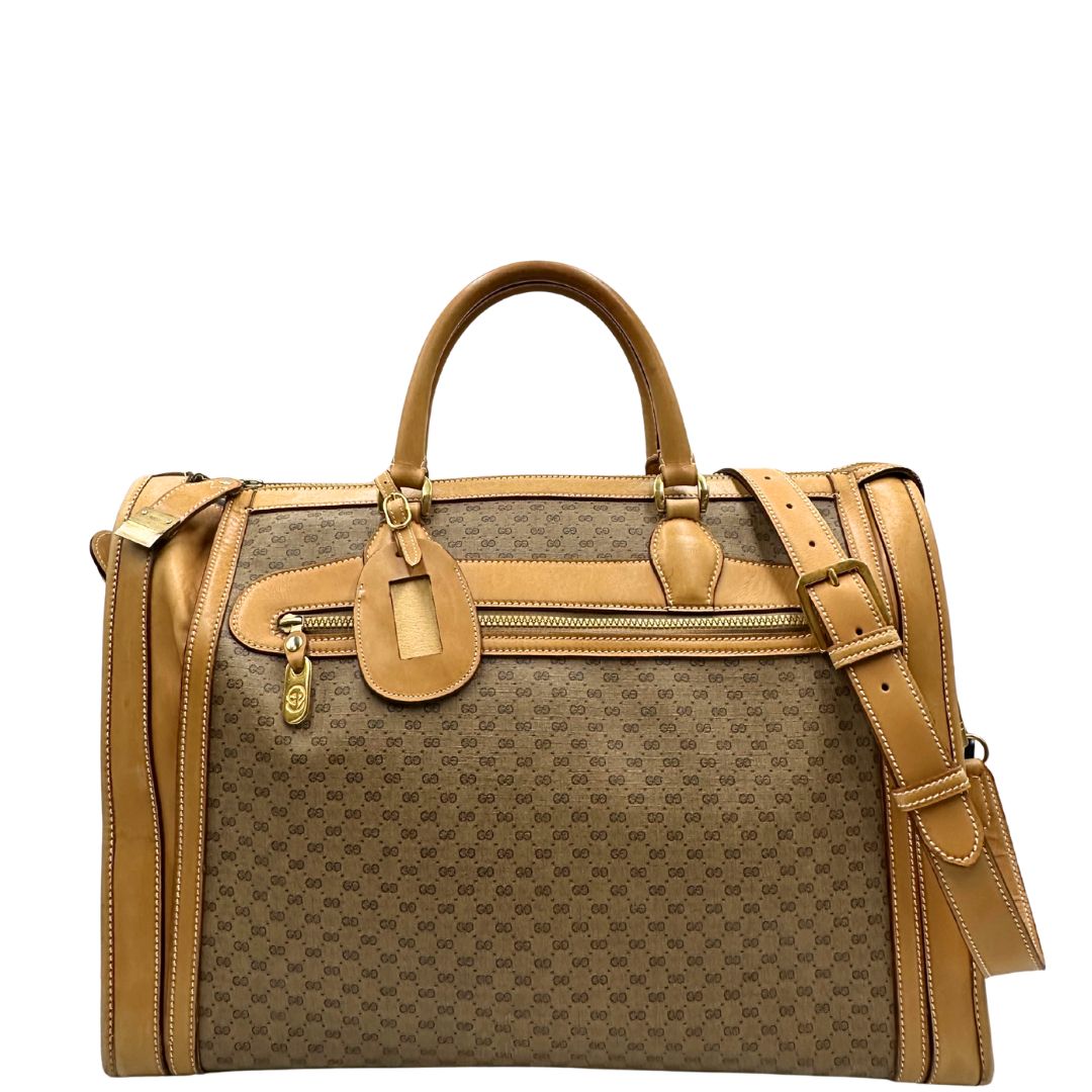 Front di una borsa Gucci in canvas beige GG con finiture in pelle color cammello e parti metalliche dorate, munita di doppi manici stondati e di una tracolla amovibile e regolabile. Dotata di tag porta address.