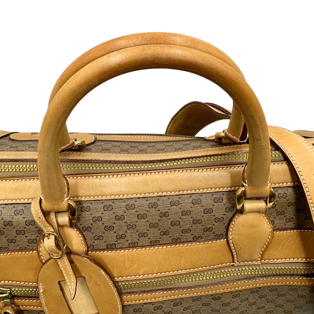 Manici di una borsa Gucci in canvas beige GG con finiture in pelle color cammello e parti metalliche dorate, munita di doppi manici stondati e di una tracolla amovibile e regolabile. Dotata di tag porta address.