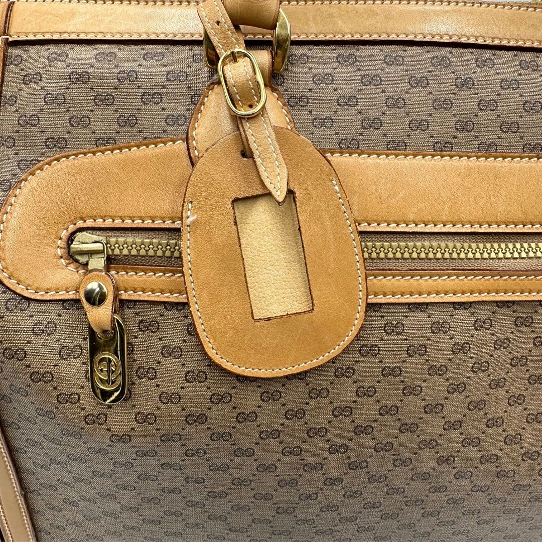 Tag porta address di una borsa Gucci in canvas beige GG con finiture in pelle color cammello e parti metalliche dorate, munita di doppi manici stondati e di una tracolla amovibile e regolabile.