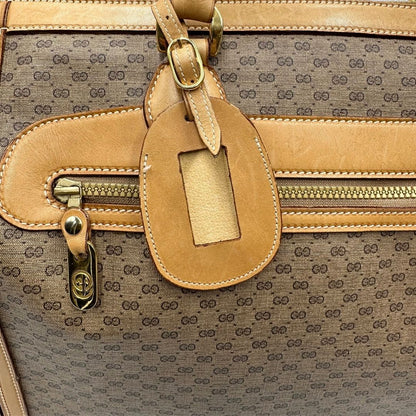 Tag porta address di una borsa Gucci in canvas beige GG con finiture in pelle color cammello e parti metalliche dorate, munita di doppi manici stondati e di una tracolla amovibile e regolabile.