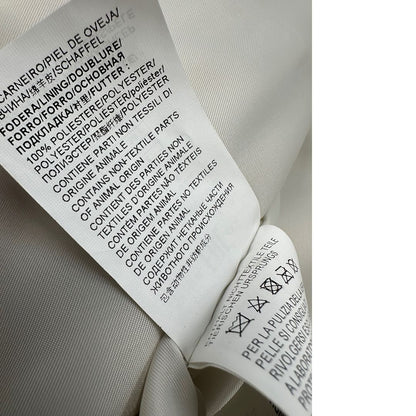 Etichetta di una giacca in 100% pelle Pinko bianco latte, con parti metalliche dorate, taglia 40.