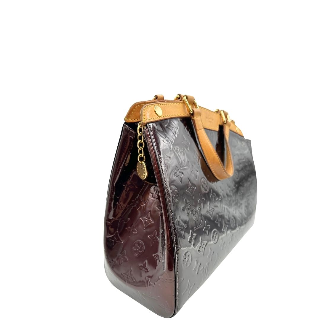 lato Borsa Louis Vuitton in pelle verniciata monogram color amaranto con parti metalliche dorate, rifinita in vacchetta naturale; munita di doppi manici e un manico amovibile e regolabile. Completa di dustbag, di lusso, originale, ottime condizioni, usata. 